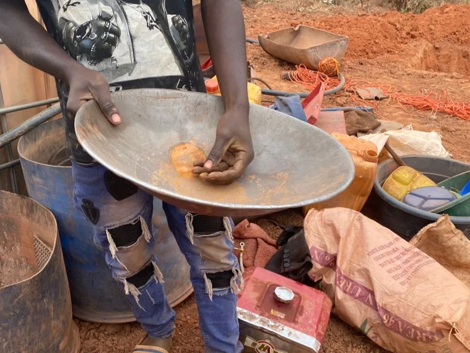 A young miner demonstrates how gold processing is done from the soil believed to contain gold particles using unregulated makeshift tools at an illegal mining site in Mukungule._2